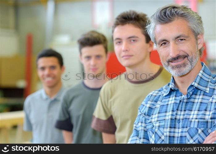 Teacher with his students lined up beside him