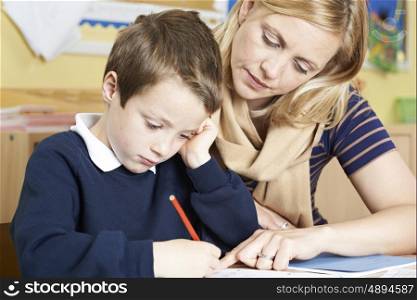 Teacher With Male Elementary School Pupil With Problem