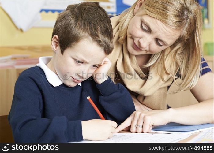 Teacher With Male Elementary School Pupil With Problem