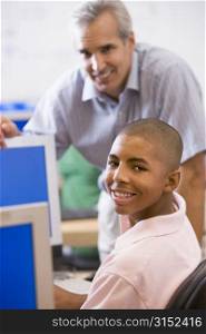 Teacher with male student in computer class