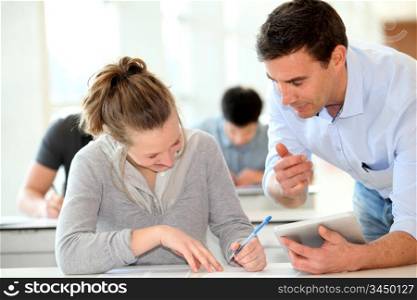 Teacher with student girl writing assignment