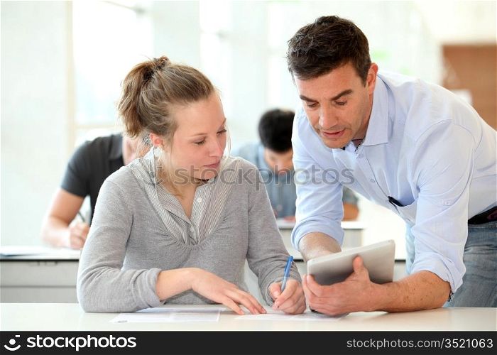 Teacher with student girl writing assignment