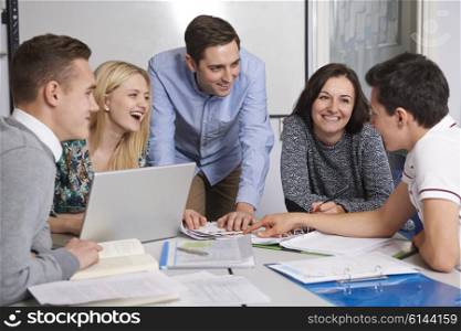 Teacher Working In Classroom With Students