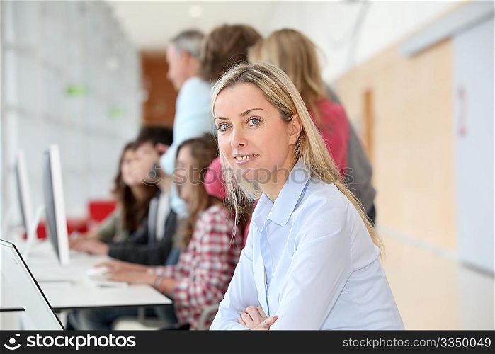 teacher working on laptop computer in classroom