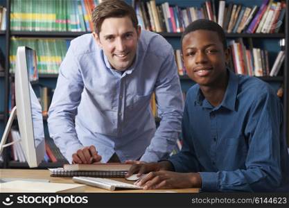 Teacher Working With Pupil At Computer