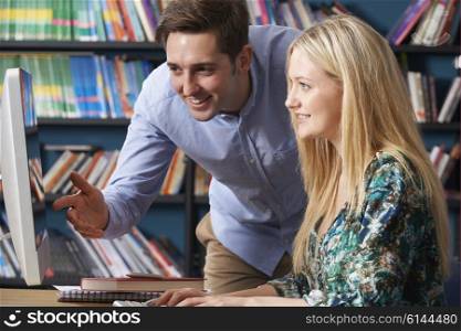 Teacher Working With Teenage Pupil At Computer