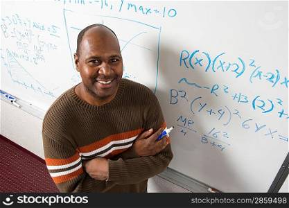 Teacher writing maths equations on whiteboard, portrait