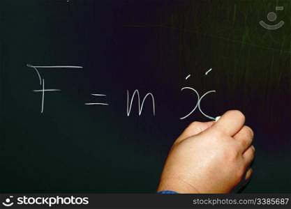 Teacher Writing Newston&rsquo;s Second Law of Motion on a Chalkboard