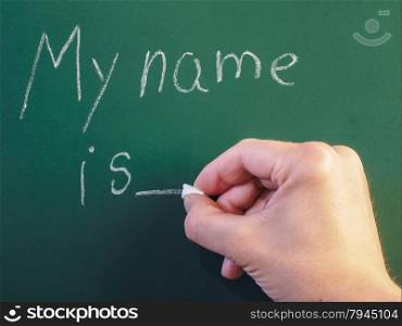 Teacher writing on green chalkboard: My name is