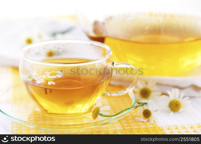 Teacup and teapot with herbal soothing camomile tea