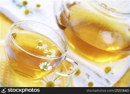 Teacup and teapot with herbal soothing camomile tea