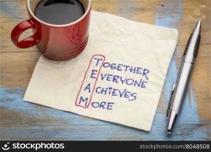 TEAM acronym (together everyone achieves more), teamwork motivation concept - a napkin doodle with a cup of coffee