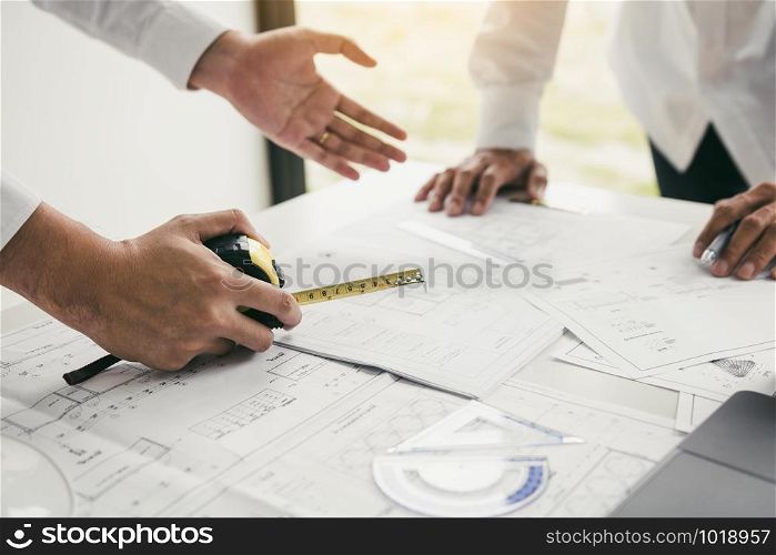 Team architect or engineering people discussion working on table together at a construction site.