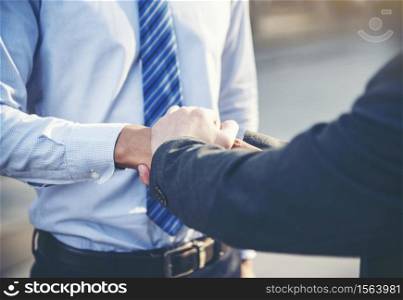 Team Business Partners shaking hands together to Greeting Start up new project. Corporate Teamwork Partnership outside office modern city as background. Businessman with Hands together.