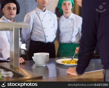 Team chefs in the kitchen presenting dish of tasty meal for restaurant manager. chefs in the kitchen presenting dish of tasty meal