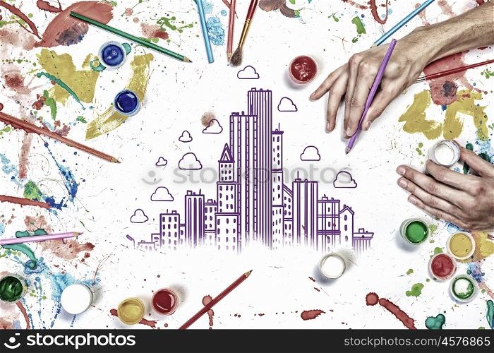 Team creative work. Top view of hands drawing buildings creative concept with paints