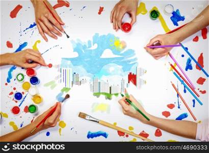 Team creative work. Top view of hands drawing buildings creative concept with paints