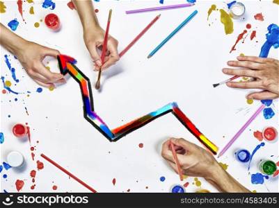 Team creative work. Top view of people hand drawing business growth concept with paints