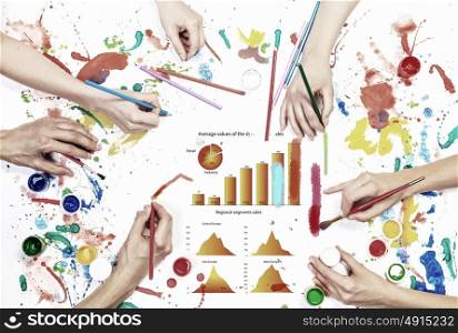 Team creative work. Top view of people hand drawing business growth concept with paints