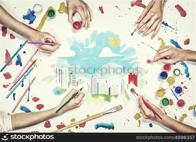 Team creative work. Top view of people hands drawing urban concept with paints