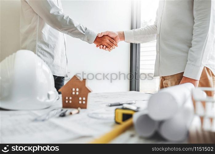 Team Engineer colleagues shaking hands and meeting for architectural project on workplace