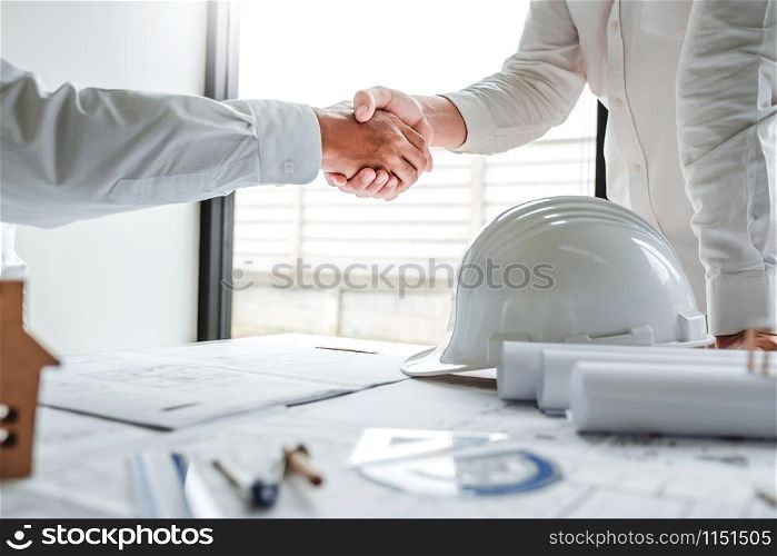 Team Engineer colleagues shaking hands and meeting for architectural project on workplace