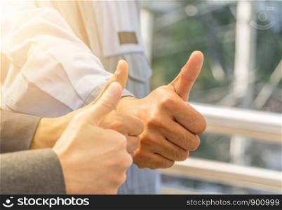 Team giving thumb up as sign of Success Business Teamwork Concept.