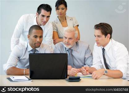 Team looking at a laptop computer