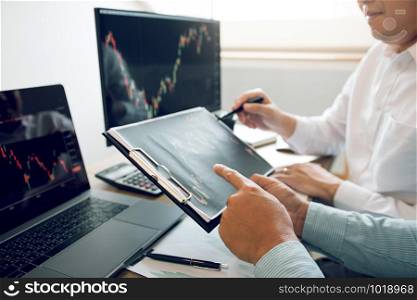Team of agent trading business people pointing graph and analysis stock market on computer screen in office.