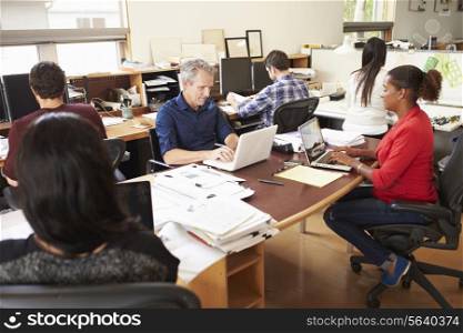 Team Of Architects Working At Desks In Office
