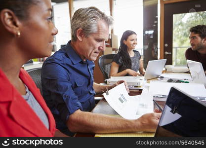 Team Of Architects Working At Desks In Office