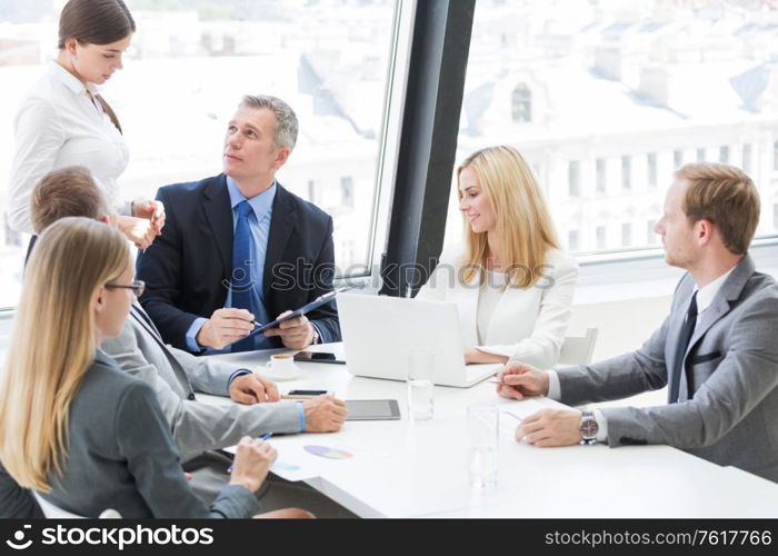 Team of business people at meeting in office discuss financial documents and statistics data. Business people at meeting