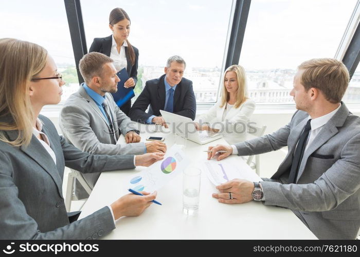 Team of business people at meeting in office discuss financial documents and statistics data. Business people at meeting