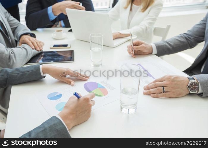 Team of business people at meeting in office discuss financial documents and statistics data. Business people at meeting