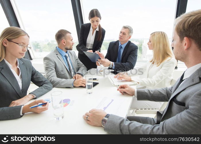 Team of business people at meeting in office discuss financial documents and statistics data. Business people at meeting