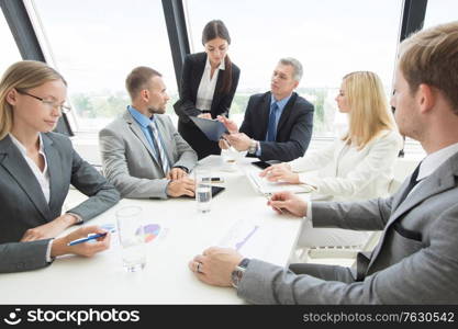 Team of business people at meeting in office discuss financial documents and statistics data. Business people at meeting