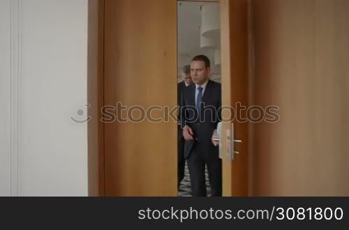 Team of business people walking in office building and discuss documents