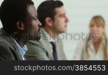 Team of business people working and talking during meeting in office room, with female colleague taking notes. 14of20