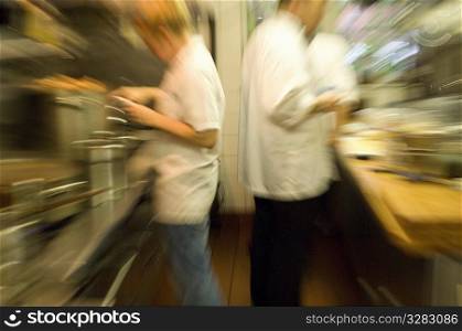 Team of busy cooks in restaurant kitchen.