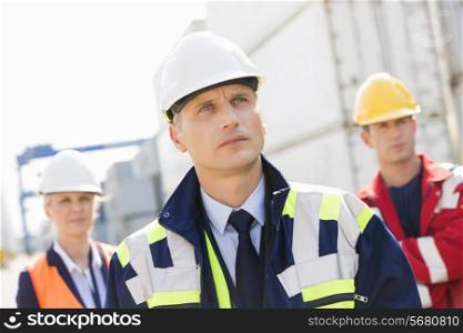Team of confident workers in shipping yard