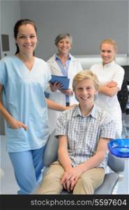 Team of dentists with teenager patient boy at dental surgery