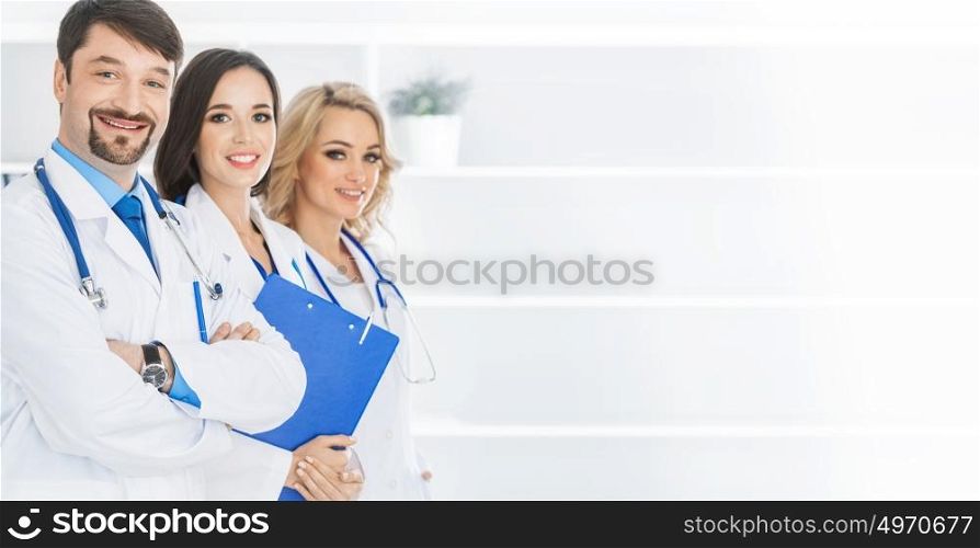 Team of doctors. Team of doctors in a clinical office, white copy space