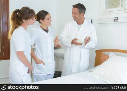 team of hospital employees in patients room