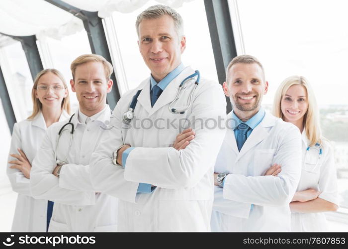 Team of medical professionals looking at camera, smiling, arms crossed. Team of medical professionals