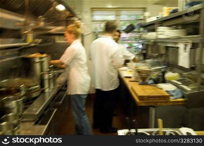 Team of restaurant kitchen staff busy at work.
