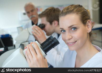 team of scientists in a laboratory working with microscopes