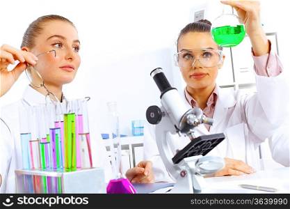 Team of scientists working with liquids in laboratory