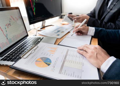 Team of stockbrokers Discussing with display screens Analyzing data, graphs and reports of stock market trading for investment