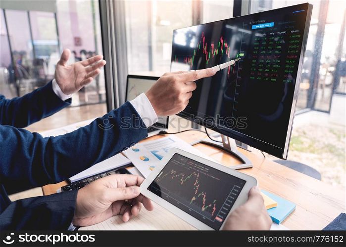 Team of stockbrokers Discussing with display screens Analyzing data, graphs and reports of stock market trading for investment