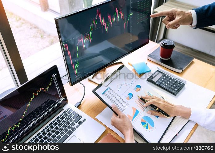 Team of stockbrokers Discussing with display screens Analyzing data, graphs and reports of stock market trading for investment